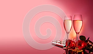 Champagne glasses, red roses in front of pink background. Valentines day holiday composition. Birthday, Women's, Wedding