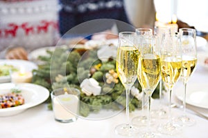 Champagne into a glasses standing on the Christmas table