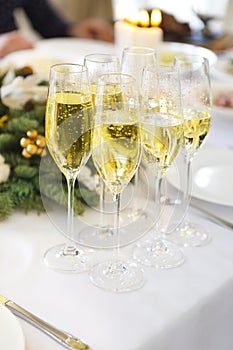 Champagne into a glasses standing on the Christmas table