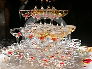 Champagne glasses standing in a tower at the wedding party. Champagne glass pyramid. Pyramid of glasses of wine, champagne, tower