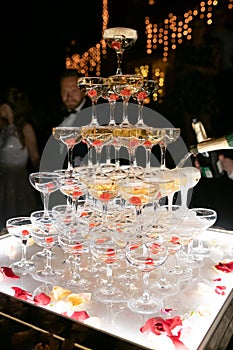 Champagne glasses standing in a tower at the wedding party. Champagne glass pyramid. Pyramid of glasses of wine, champagne, tower