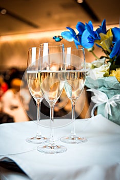 Champagne in glasses on the table with flowers.