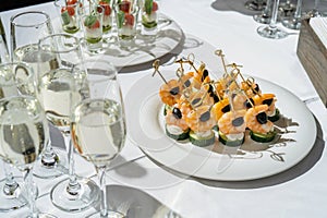 Champagne glasses on the table. shrimp and olives for appetizer.