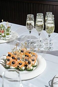 Champagne glasses on the table. shrimp and olives for appetizer.