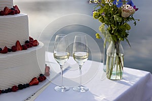 champagne glasses with wedding cake and flowers photo