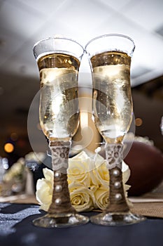 Champagne glasses and white roses
