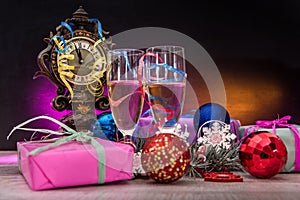 Champagne in glasses on wooden table with colorful Christmas presents