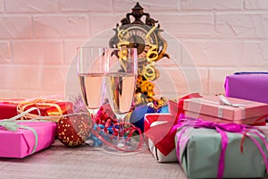 Champagne in glasses on wooden table with colorful Christmas presents