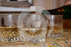 Champagne is poured into glass glasses with a thick bottom