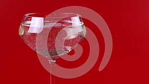 Champagne is poured into a glass on a red background