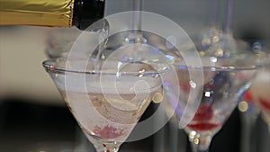 Champagne pouring in two glasses from a bottle. Two Champagne Glass On Defocused