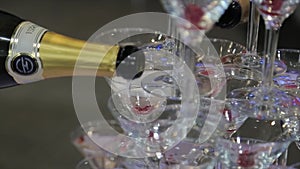 Champagne pouring in two glasses from a bottle. Two Champagne Glass On Defocused. Pouring champagne into fancy glasses