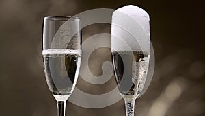 Champagne pouring in two glasses of steamy green bottle. Bokeh background. Close up