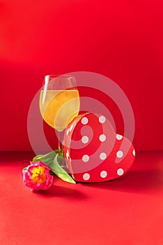 Champagne, present and flower on red background