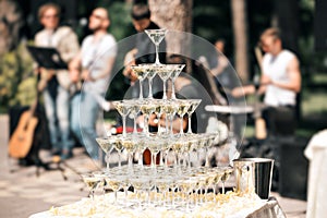 Champagne pyramid on event, party or banquet. cherry in the glass. the band in the background