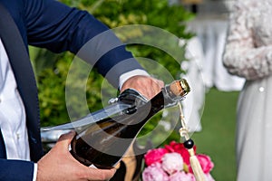 champagne saber close-up while open a bottle in a wedding photo