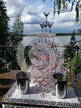 Champagne slide. Pyramid or fountain made of champagne glasses with cherry