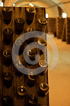 Champagne sparkling wine production in bottles in racks in underground cellar, Reims, Champagne, France