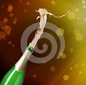 Champagne splashing out of bottle on background