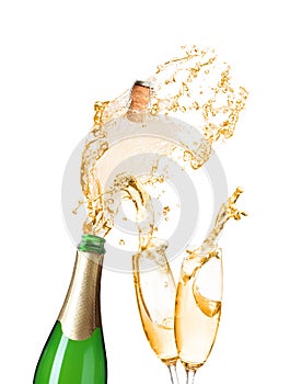 Champagne splashing out of bottle and glasses on background