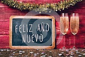 Champagne and text feliz ano nuevo, happy new year in spanish