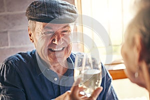 Champagne toast, celebration and senior couple with smile about retirement at restaurant. Elderly man and woman at