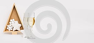 Champagne in two elegant glasses, Christmas tree, toys light background. Festive winter holidays Christmas and New Year