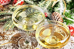 Champagne in two elegant glasses on a festive Christmas table with gifts a decorated Christmas tree. New Year concept.