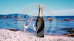 Champagne wine and glasses on the beach. Picnic on the sea, holiday