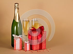 Champagne, wine glasses, boxes of gifts decorated with bow, on b