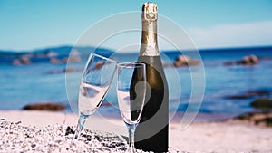 Champagne wine and glasses on seashore. Beach party