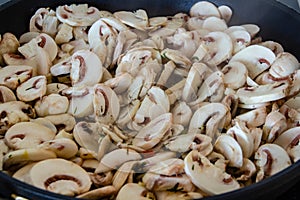 Champignon mushrooms are fried in a frying pan