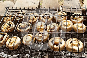 Champignon mushrooms are grilled. Fry mushrooms on a homemade stone grill.