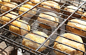 Champignon mushrooms are grilled. Fry mushrooms on a homemade stone grill.