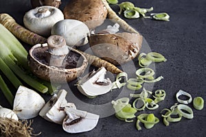 Champignons, leek, parsnip, garlic and fennel on grey background. Top view photo of fresh seasonal vegetables. Healthy menu ideas.