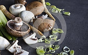 Champignons, leek, parsnip, garlic and fennel on grey background. Top view photo of fresh seasonal vegetables. Healthy menu ideas.