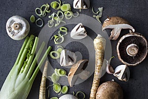 Champignons, leek, parsnip, garlic and fennel on grey background. Top view photo of fresh seasonal vegetables. Healthy menu ideas.