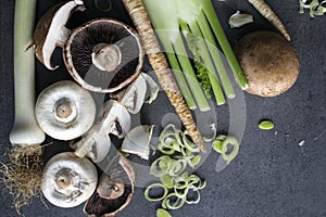 Champignons, leek, parsnip, garlic and fennel on grey background. Top view photo of fresh seasonal vegetables. Healthy menu ideas.