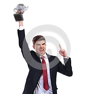 Champion businessman holding trophy and pointing finger up