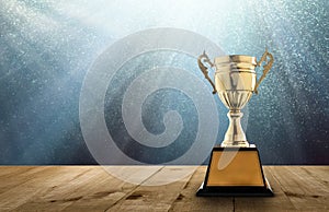 champion golden trophy on wood table with copy space and blue Twinkly Lights and glitter stars light background copy space ready