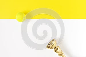 Champion trophy cup and tennis ball isolated on white and yellow background. copy space. Sports. Top view, flatlay