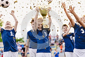 Champion youth soccer team with winning trophy. Boys football team celebrating victory in school competition