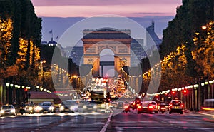 Champs-Elysees Avenue with traffic Arc de Triomphe in Paris France at night. car traffic with many cars on the street