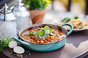 chana masala being served onto a plate from a pot