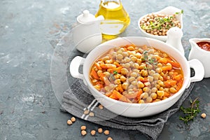 Chana Masala, spicy chickpea curry with carrot and onion in tomato sauce. Vegetarian dish for lunch closeup