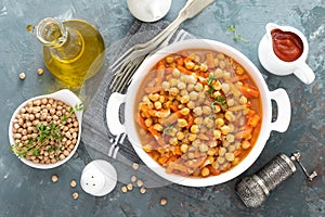 Chana Masala, spicy chickpea curry with carrot and onion in tomato sauce. Vegetarian dish for lunch. Indian cuisine