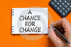 A chance for change symbol. Concept words A chance for change on beautiful white note. Beautiful orange background. Voter hand.