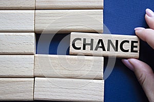 Chance symbol. Concept word Chance on wooden blocks. Businessman hand. Beautiful deep blue background. Business and Chance concept