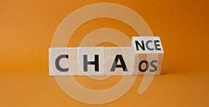 Chance vs Chaos symbol. Turned wooden cubes with words Chaos and Chance. Beautiful orange background. Psychology and Chance vs