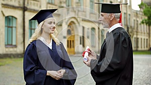 Chancellor of university giving diploma to graduating student, successful future photo